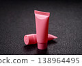 Pink empty plastic tube for cream, paste or shampoo as a mockup. Empty cosmetic tube mockup 138964495