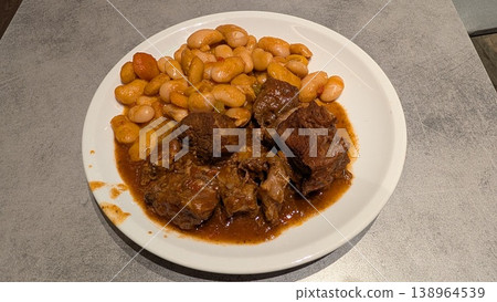 Kokkinisto, a classic Greek beef stew in tomato sauce with baked giant beans on a white plate Kokkinisto, a classic Greek beef stew in tomato sauce with baked giant beans on a white plate 138964539