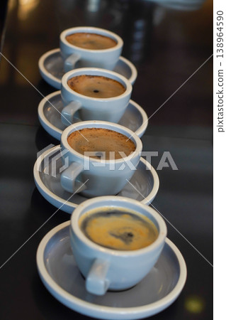 Row of espresso cups with crema and shallow focus, ideal for cafe, beverage, and coffee lifestyle themes 138964590