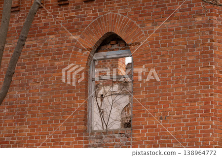 Arched Window in Red Brick Wall of Abandoned Old Building Showing Interior Ruins Arched Window in Red Brick Wall of Abandoned Old Building Showing Interior Ruins 138964772