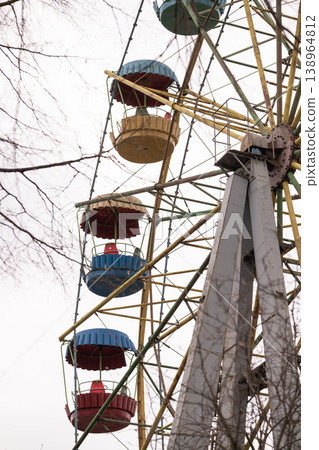 Vintage Ferris Wheel Structure with Colorful Gondolas and Metal Frame Against Sky Vintage Ferris Wheel Structure with Colorful Gondolas and Metal Frame Against Sky 138964812