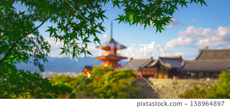 Kyoto, Japan - Oct 11 2024, panoramic view through foliage of Kiyomizu-Dera temple complex with a pagoda, with a clear blue sky and a forest in foreground, at daytime, blurred, Kyoto, Japan 138964897