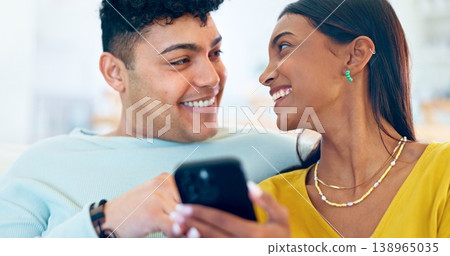 Couple, phone and happy on sofa, laugh or reading for funny story, notification or post on web blog. Man, woman and smartphone for meme, streaming comic video or memory on social network app in home 138965035