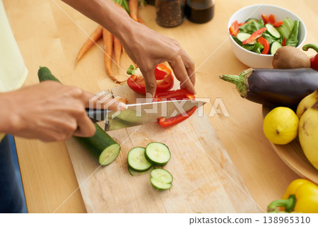 Closeup, hands and cutting with vegetables, nutrition and plant based diet in a kitchen. Person, home and cooking health food, lunch and vegan meal with variety, vitality and weight loss with knife Closeup, hands and cutting with vegetables, nutrition and plant based diet in a kitchen. Person, home and cooking health food, lunch and vegan meal with variety, vitality and weight loss with knife 138965310