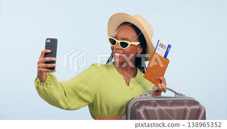 Black woman, selfie with suitcase and passport for travel, vacation and social media post on blue background. Luggage, smile in picture with plane ticket and booking documents for adventure in studio 138965352