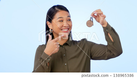 Smile, woman and pointing at keys for real estate, new home and property in studio isolated on a blue background mockup space. Happy person with keychain for house mortgage, apartment rent and moving 138965386
