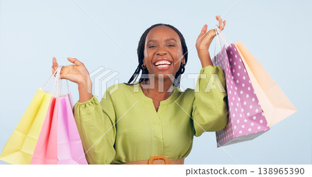 Black woman, shopping bag and retail in portrait with happiness for discount on fashion giveaway in studio. Choice, happy and commerce with smile for sale, service and gift on blue background Black woman, shopping bag and retail in portrait with happiness for discount on fashion giveaway in studio. Choice, happy and commerce with smile for sale, service and gift on blue background 138965390