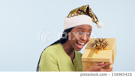Excited black woman, box and Christmas surprise for gift, present or prize against a studio background. Face of happy and surprised African female person holding ribbon package, parcel or gifts Excited black woman, box and Christmas surprise for gift, present or prize against a studio background. Face of happy and surprised African female person holding ribbon package, parcel or gifts 138965428