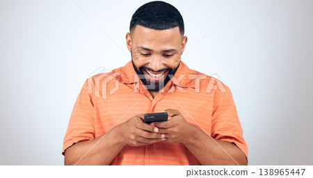 Man in studio with phone, smile and typing with connection for networking, online chat or communication. Good news, notification and happy person writing message, email or post on white background. Man in studio with phone, smile and typing with connection for networking, online chat or communication. Good news, notification and happy person writing message, email or post on white background. 138965447