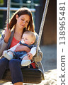 Woman, baby and swing on park for play, bonding and love with sunshine, child development and care. Mother, kid and infant swinging outdoor in summer for fun, enjoyment and nurture with happiness 138965481