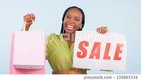 Happy black woman, portrait and shopping bag, sale sign or discount against a studio background. Excited African female person smile with gift bags, show or poster for store promotion or deal Happy black woman, portrait and shopping bag, sale sign or discount against a studio background. Excited African female person smile with gift bags, show or poster for store promotion or deal 138965538