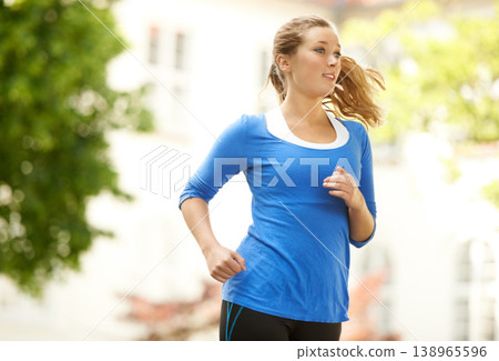 Neighborhood, running and woman with fitness in exercise or outdoor cardio workout in urban, city or town. Healthy, runner or training with energy, motivation and goals for wellness in summer or park 138965596