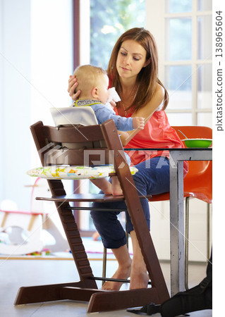 Woman, baby and food in feeding chair for nutrition, growth and development at table in kitchen of home. Mother, infant and cleaning face after eating, napkin and routine for love, care and nurture Woman, baby and food in feeding chair for nutrition, growth and development at table in kitchen of home. Mother, infant and cleaning face after eating, napkin and routine for love, care and nurture 138965604