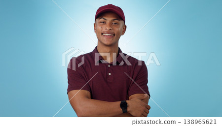 Delivery man, arms crossed or portrait for distribution or mockup space on blue background. Professional, retail supply chain or happy logistics worker for shipping or courier service in studio 138965621