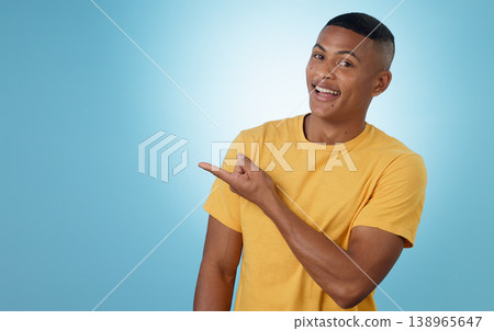 Man, student pointing and presentation for education, learning or college news and information in studio. Portrait of a young person with university guide, advice and mockup on a blue background Man, student pointing and presentation for education, learning or college news and information in studio. Portrait of a young person with university guide, advice and mockup on a blue background 138965647