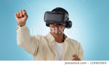 Man, punch and virtual reality glasses in studio for gaming, 3D user experience and metaverse by blue background. Person, gamer and ar vision with fight, competition and esports contest for boxing 138965669