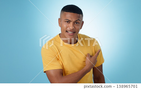 Pointing, question and portrait of man in a studio with mockup for marketing, advertising or promotion. Confused, thinking and young male person with a show hand gesture isolated by blue background. Pointing, question and portrait of man in a studio with mockup for marketing, advertising or promotion. Confused, thinking and young male person with a show hand gesture isolated by blue background. 138965701