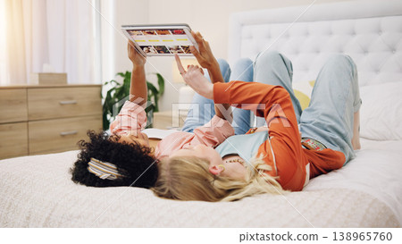 Friends relax with tablet to scroll on website for a movie or film choice lying on bed together at home. Technology, decision or people on internet search for ecommerce online shopping on app screen 138965760