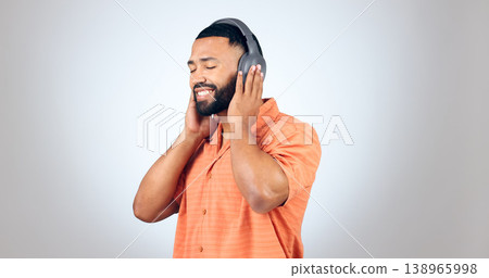 Man, listening and headphones with music in studio, background or mockup with audio streaming. Radio, podcast and calm person relax with hip hop or download sound online to hear with technology 138965998