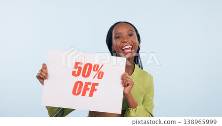 Portrait, sale and poster with a retail black woman in studio on blue background for promo discount. Smile, shopping and savings with a happy young commercial employee holding a sign for information Portrait, sale and poster with a retail black woman in studio on blue background for promo discount. Smile, shopping and savings with a happy young commercial employee holding a sign for information 138965999