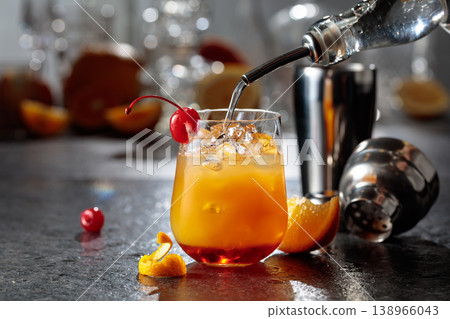 Making Tequila sunrise cocktail on a stone table in bar. 138966043