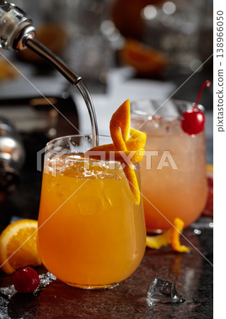 Tequila sunrise cocktail garnished with orange zest. 138966050