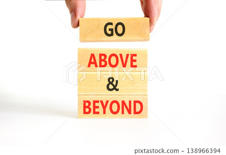 Go above and beyond symbol. Concept words Go above and beyond on beautiful wooden blocks. Beautiful white background. Businessman hand. Business motivational Go above and beyond concept. Copy space. Go above and beyond symbol. Concept words Go above and beyond on beautiful wooden blocks. Beautiful white background. Businessman hand. Business motivational Go above and beyond concept. Copy space. 138966394