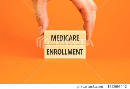 Medicare enrollment words symbol. Concept words Medicare enrollment on beautiful wooden blocks. Beautiful orange background. Doctor hand. Medical and Medicare enrollment words concept. Copy space. Medicare enrollment words symbol. Concept words Medicare enrollment on beautiful wooden blocks. Beautiful orange background. Doctor hand. Medical and Medicare enrollment words concept. Copy space. 138966442