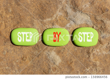 Next step words symbol. Concept words Step by step on beautiful green stones. Beautiful stone beach background. Business and next step concept. Copy space. 138966456
