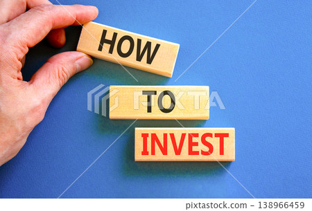 How to invest words symbol. Concept words How to invest on beautiful wooden blocks. Beautiful blue background. Businessman hand. Business and how to invest concept. Copy space. 138966459