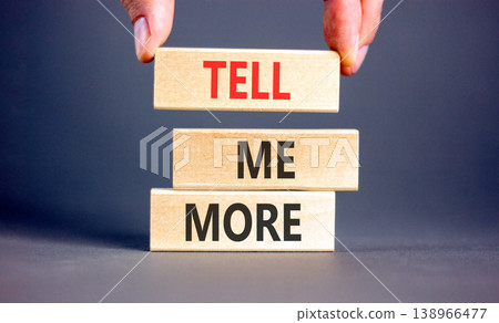 Tell me more words symbol. Concept words Tell me more on beautiful wooden blocks. Beautiful grey background. Businessman hand. Business and tell me more concept. Copy space. 138966477