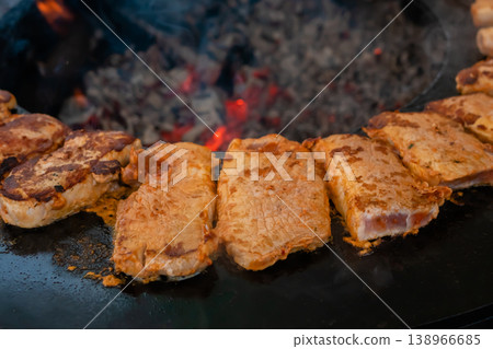 Process of cooking meat steaks on round brazier - close up Process of cooking meat steaks on round brazier - close up 138966685