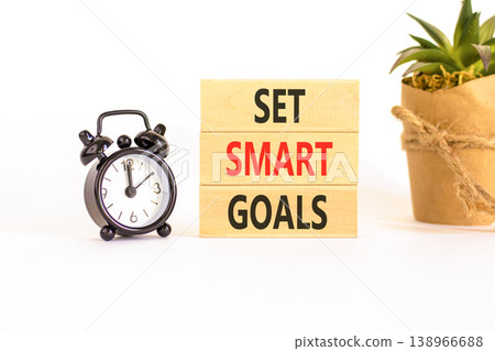 Set smart goals words symbol. Concept words Set smart goals on beautiful wooden blocks. Beautiful white background. Black alarm clock. House plant. Business and set smart goals concept. Copy space. 138966688