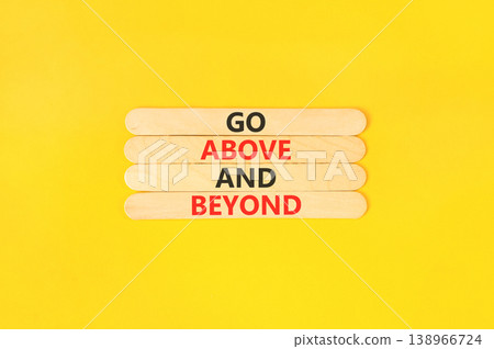 Go above and beyond words symbol. Concept words Go above and beyond on beautiful wooden sticks. Beautiful yellow background. Business motivational Go above and beyond concept. Copy space. 138966724