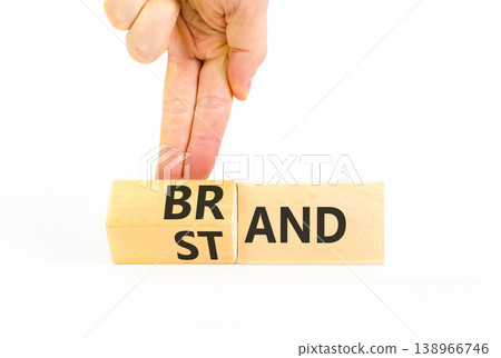 Brand or stand symbol. Concept words Brand Stand on beautiful wooden blocks. Beautiful white background. Businessman's hand. Business brand or stand concept. Copy space. Brand or stand symbol. Concept words Brand Stand on beautiful wooden blocks. Beautiful white background. Businessman's hand. Business brand or stand concept. Copy space. 138966746