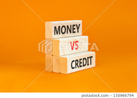 Money vs credit words symbol. Concept words Money vs credit on beautiful wooden blocks. Beautiful orange background. Business and money vs credit concept. Copy space. 138966794