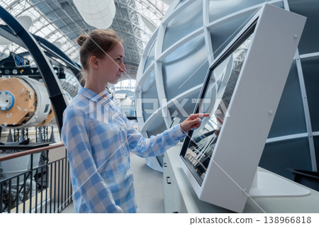 Woman touching interactive touchscreen display kiosk at exhibition - side view Woman touching interactive touchscreen display kiosk at exhibition - side view 138966818