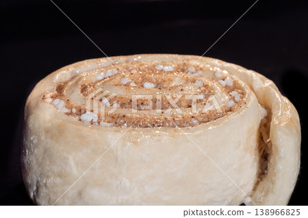 One uncooked cinnamon bun in electric oven, black background One uncooked cinnamon bun in electric oven, black background 138966825