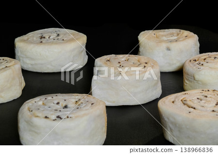 Many uncooked homemade buns with poppy seeds on tray in electric oven 138966836