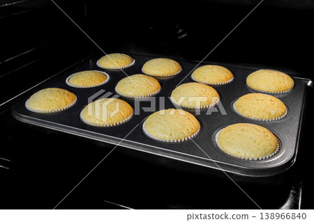 Homemade cupcakes, muffins baking and rising in electric oven 138966840
