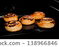 Five baked cinnamon buns in electric oven at home 138966846