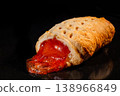 One baked bun with strawberry jam in electric oven: black background, close up 138966849