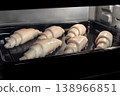 Six uncooked homemade croissants on tray in electric oven 138966851