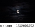 Moon rising against black sky with clouds at night 138966852