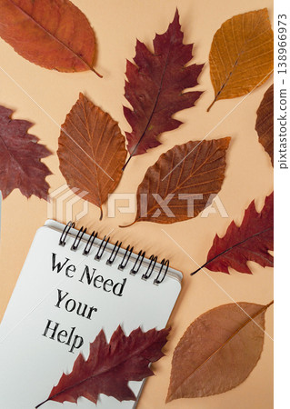 Autumn leaves scattered around a notepad with a handwritten message, creating a warm seasonal atmosphere, inviting assistance and collaboration in a creative context Autumn leaves scattered around a notepad with a handwritten message, creating a warm seasonal atmosphere, inviting assistance and collaboration in a creative context 138966973