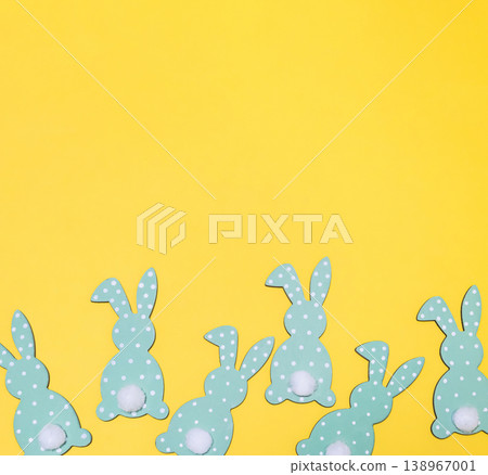 Row of green and white rabbits are lined up on a yellow background Row of green and white rabbits are lined up on a yellow background 138967001
