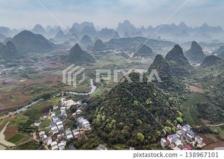 Misty hills rise gently behind a quiet village of China Misty hills rise gently behind a quiet village of China 138967101