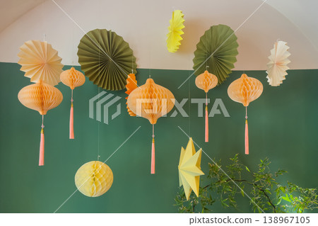 Pastel paper lanterns hang softly against a green wall Pastel paper lanterns hang softly against a green wall 138967105