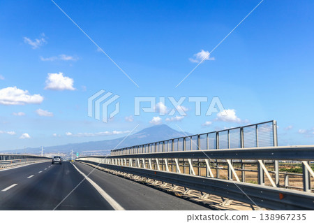 Sunny day on Sicilian road with vehicles and picturesque volcanic landscape Sunny day on Sicilian road with vehicles and picturesque volcanic landscape 138967235