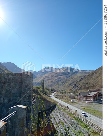 Alan Monastery stone complex, North Ossetia, Russia, summer daylight. Traditional Ossetian monastery built of stone on a grassy mountain slope Alan Monastery stone complex, North Ossetia, Russia, summer daylight. Traditional Ossetian monastery built of stone on a grassy mountain slope 138967254